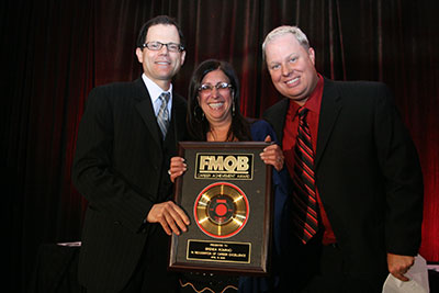 Brenda Romano receives her accolade from Fred Deane and emcee Paul "Cubby" Bryant.